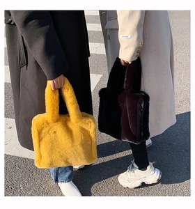 Outdoor lifestyle shot of two models carrying plush faux fur tote bags in yellow and black