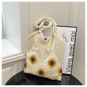 Detail shot of handcrafted woven sunflower tote bag with cream cotton texture and tassels