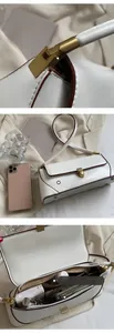 Detail view of white leather baguette bag interior capacity and matte gold hardware