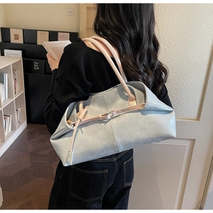 Details der hellblauen Shopper-Tasche mit beigen Ledergriffen in einer Bibliothek