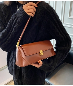 French retro style brown leather baguette bag with gold buckle on shoulder detail
