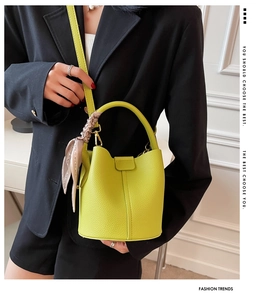 Sac seau vert citron avec détail de foulard en soie et finitions dorées sur blazer noir