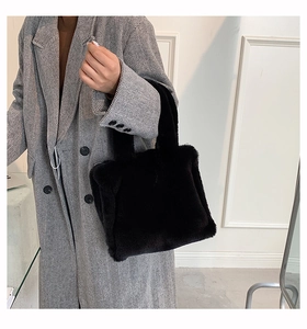 Detail of soft black faux fur tote bag paired with a grey herringbone coat for autumn