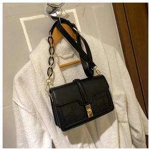 Détail du sac à bandoulière noir motif pierre avec chaîne acrylique et boucle dorée