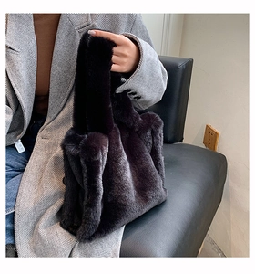 Close-up of fluffy black faux fur tote bag with plush texture and wide handles