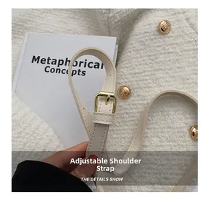 Gros plan sur la bandoulière réglable en cuir blanc cassé avec boucle dorée rétro