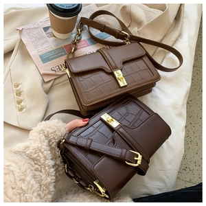 Détails de petits sacs carrés motif crocodile marron sur une veste de costume beige