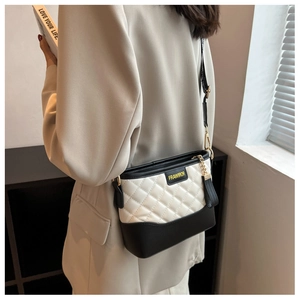 Close-up of diamond-quilted pattern on black and white crossbody bag for women