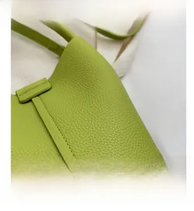 Gros plan sur le cuir grainé litchi vert clair et les coutures de ce sac à main