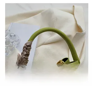 Détail de la poignée du sac seau vert avec foulard en soie et fermoir en métal doré
