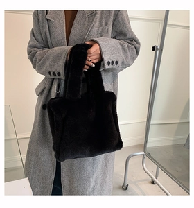 Close-up of soft black faux fur tote bag styled with a grey herringbone wool coat