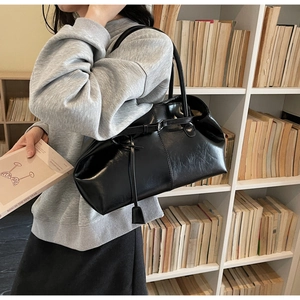 Détail d'un sac cabas noir minimaliste avec texture plissée et doubles bretelles chics