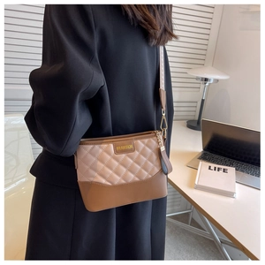 Detail of a square crossbody bag with beige quilted leather and contrast brown panel
