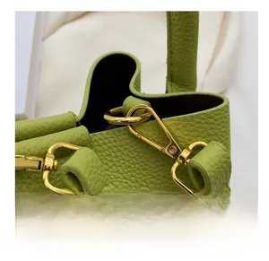 Détail du crochet en métal doré et de la texture du cuir vert sur le sac à main