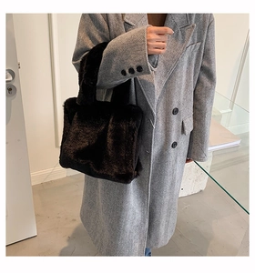 Faux fur tote bag in black shown with a wool coat for a stylish winter look