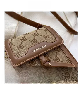 Detail of monogram jacquard canvas and brown leather flap on a retro crossbody bag