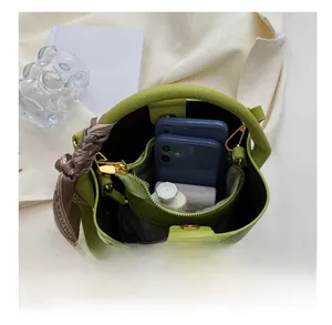 Détail de la capacité du sac seau vert avec pochette interne et foulard en soie