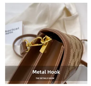 Detailed close-up of golden metal hooks and premium brown leather on stylish handbag