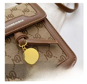 Detail of precise stitching on the brown monogram canvas and leather crossbody bag