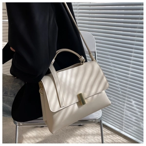 Détail d'un sac à main en cuir PU crème avec boucle en métal doré et rabat rectangulaire