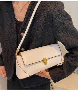 Detailed close-up of a white rectangular leather baguette bag with gold buckle clasp