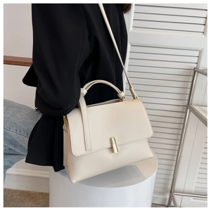 Détail du sac bandoulière minimaliste en cuir crème avec fermoir doré élégant