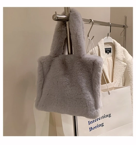 Detailed view of gray faux fur tote bag hanging with stylish plush texture and soft handle