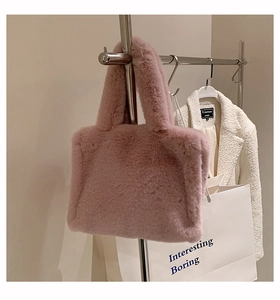 Close-up of fluffy pink plush tote bag with soft texture hanging on a metal rack