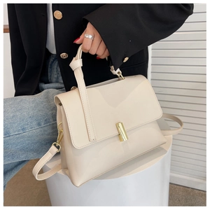 Détail d'un sac à main en cuir crème avec fermoir doré et poignée nouée élégante