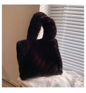 Close-up of soft dark plush tote bag showing fuzzy faux fur texture on white fabric