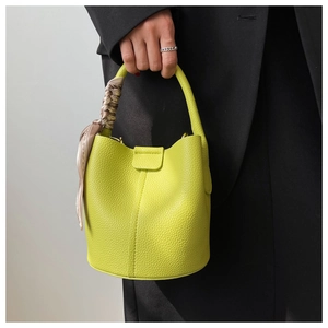 Détail du sac seau jaune citron en cuir grainé avec une poignée en foulard de soie