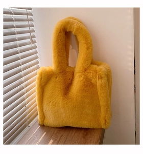 Close-up of ginger plush bucket bag showing soft faux fur texture in natural sunlight