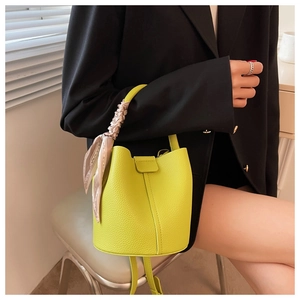 Détail d'un sac seau vert citron avec texture lychee et foulard en soie décoratif