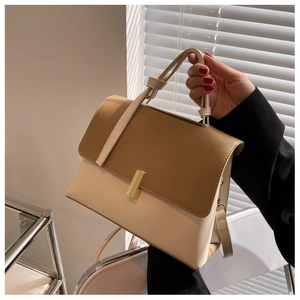 Détail d'un sac à main bicolore chic avec fermoir métallique et poignée ajustable