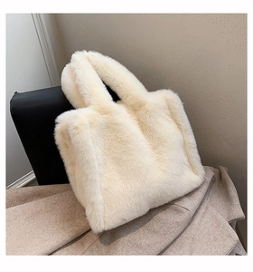 Detailed texture of off-white plush faux fur on a minimalist shoulder tote bag