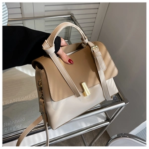 Détail d'un sac à main bicolore beige et marron avec fermoir métallique doré élégant