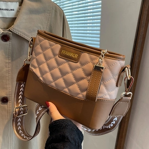 Quilted crossbody bag with wide strap and gold hardware in earth tone colors