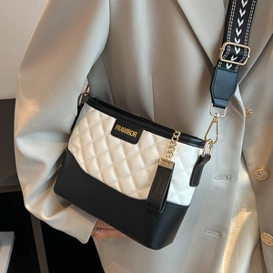 Quilted black and white crossbody bag with wide patterned strap and golden logo