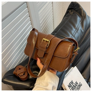 Detail of vintage brown shoulder bag showing glossy PU leather and gold buckle hardware