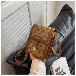 Detail of vintage flap crossbody bag with N-letter monogram and brown leather trim