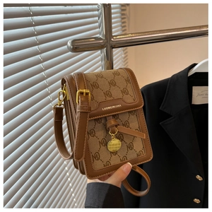 Detail of a brown monogram crossbody bag with flap closure and adjustable leather strap