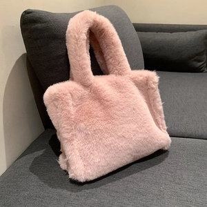 Pink plush faux fur tote bag for women shown on a grey fabric sofa for autumn and winter