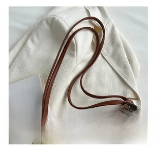 Close-up of woven canvas tote bag showing brown leather handle and texture