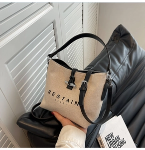 Detail of canvas tote bag showing iconic silver bamboo clasp and leather trim finishes