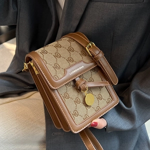 Retro brown crossbody square bag featuring monogram fabric and gold metal pendant