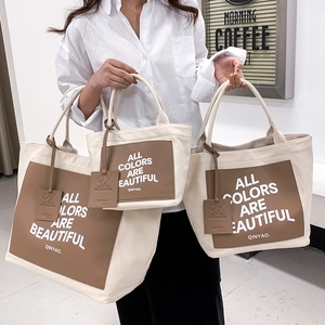 Three sizes of canvas tote bags with leather trim in cream and brown for women