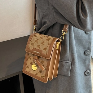 Brown monogram crossbody bag with gold hardware and leather trim in a minimalist style