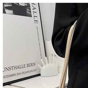Detail of minimalist beige leather tote bag styled with a professional black blazer