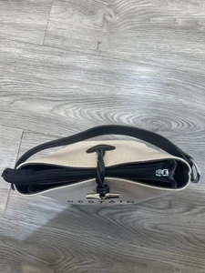 Top view of canvas tote bag showing black leather trim, zipper closure and metal T-toggle