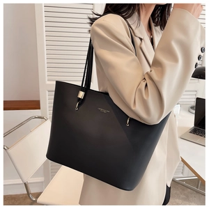 Detail of elegant black PU leather tote bag with gold hardware and shoulder strap